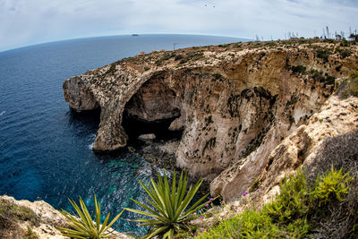 Scenic view of rock formation in sea against sky