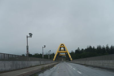 Street lights on bridge against sky