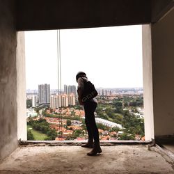 Woman looking down from window in incomplete building