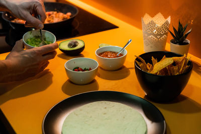 Cropped hand of person preparing food on table