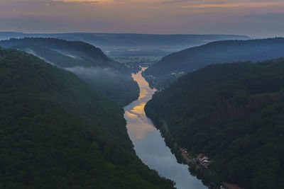 High angle view of river amidst mountains against sky