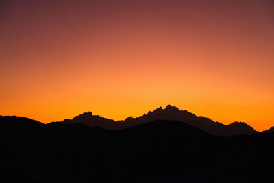 Scenic view of silhouette mountains against clear sky during sunset