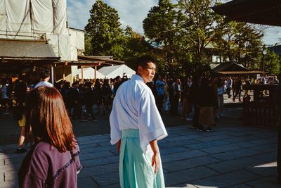 Rear view of people enjoying in front of building