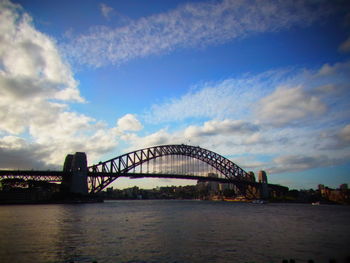 Bridge over river against cloudy sky