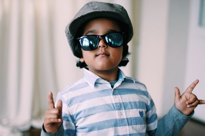 Close-up portrait of boy wearing sunglasses at home