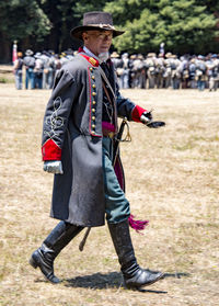 Full length of man wearing hat standing against wall