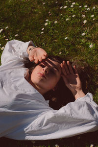 High angle of woman lying on grassy field