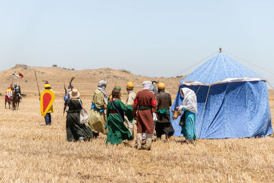 Group of people on field against clear sky