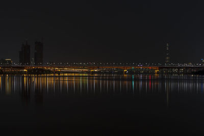 View of river with buildings illuminated at night
