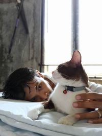 Portrait of young woman with cat relaxing outdoors