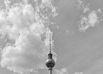 Low angle view of communications tower against cloudy sky