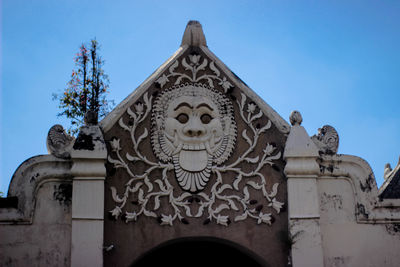 Low angle view of sculptures on building against sky