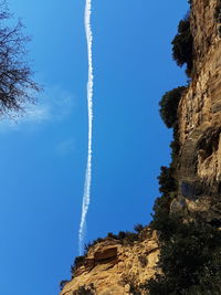 Low angle view of vapor trail against blue sky