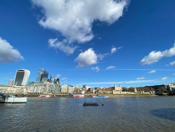 View of buildings by sea against cloudy sky