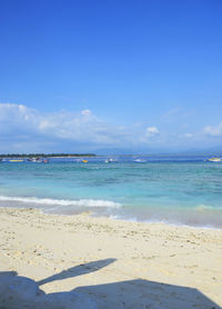 Scenic view of beach against blue sky