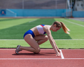 Full length of woman exercising on field