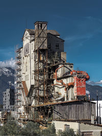 Low angle view of old industrial building against blue sky