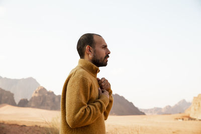 Contemplative man standing at desert