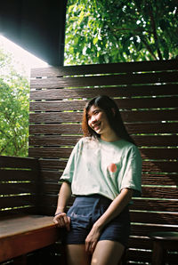 Portrait of a smiling young woman sitting on bench