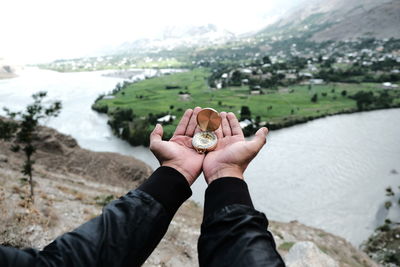 Cropped hands of person holding navigational compass