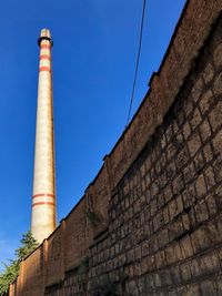 Low angle view of factory against blue sky