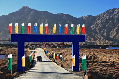 Multi colored flags on mountain against sky