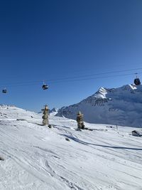 Overhead cable car against snowcapped mountains against clear blue sky