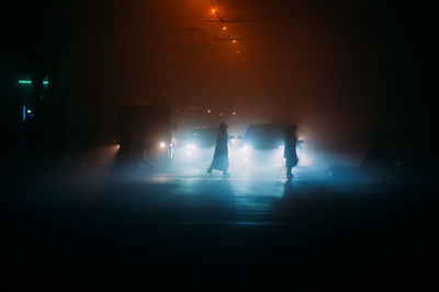 Fog in the night city after rain, car headlights