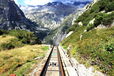 Panoramic view of railroad tracks leading towards mountains