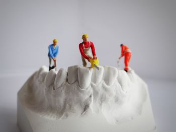 Close-up of figurine on table against white background