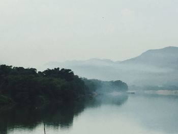 Scenic view of lake by trees against sky