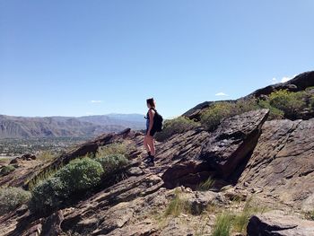 Woman photographing against clear sky