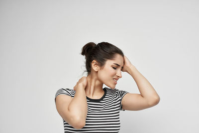 Young woman looking away against white background