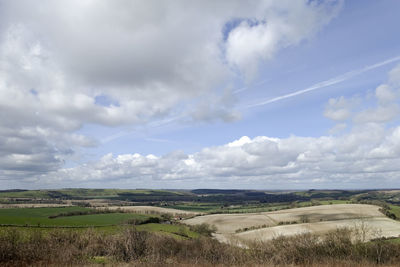 Scenic view of field against cloudy sky