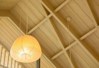 Low angle view of illuminated pendant lights hanging from ceiling