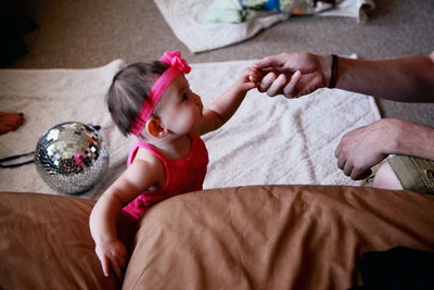 High angle view of father holding baby girl at home