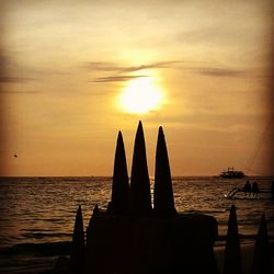 Silhouette people on beach against sky during sunset