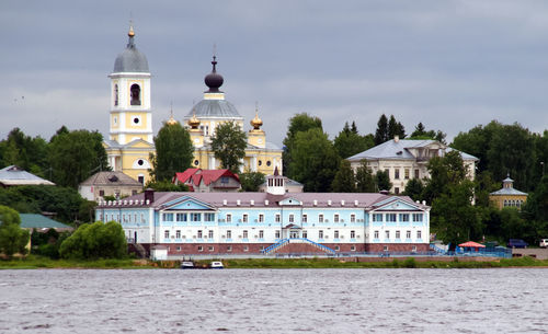 View of building by river against sky