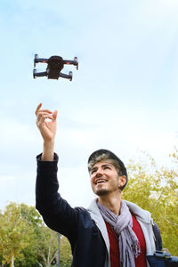 Smiling man looking at quadcopter