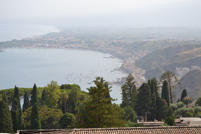 Scenic view of cityscape and trees against sky