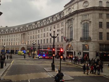 People walking in city against sky