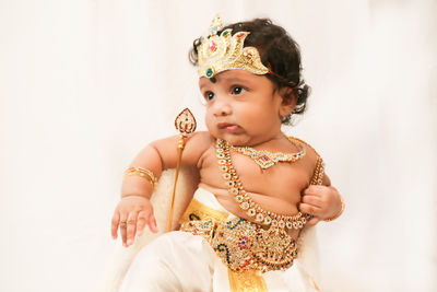 Portrait of smiling young woman in lingerie standing against white background