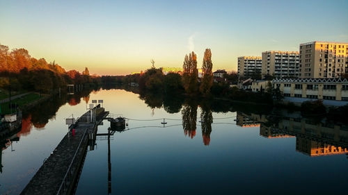 River by city against sky during sunset