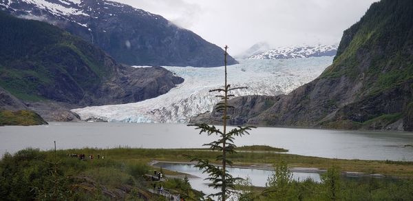 Scenic view of lake by mountains against sky