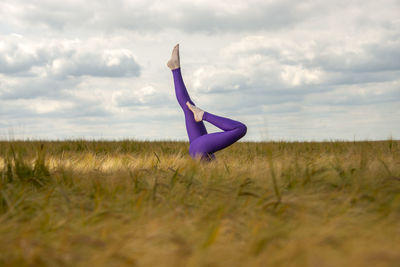 Legs in a field. woman doing a headstand in the middle of a field