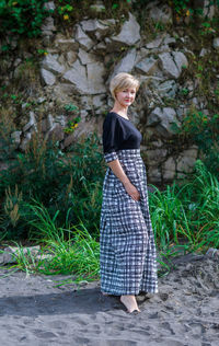 Full length of young woman standing against wall