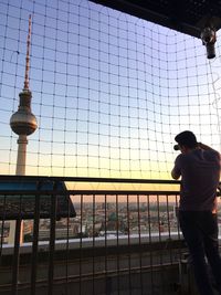 Rear view of man standing against sky during sunset