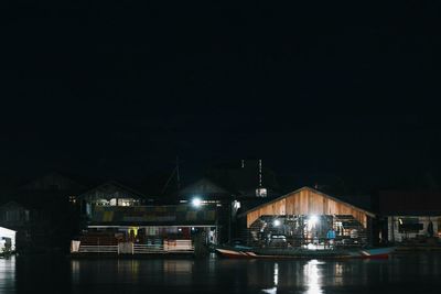 Illuminated harbor against sky at night