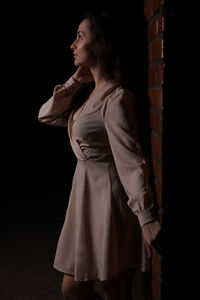 Side view of woman standing in darkroom
