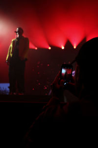 Rear view of man photographing with mobile phone